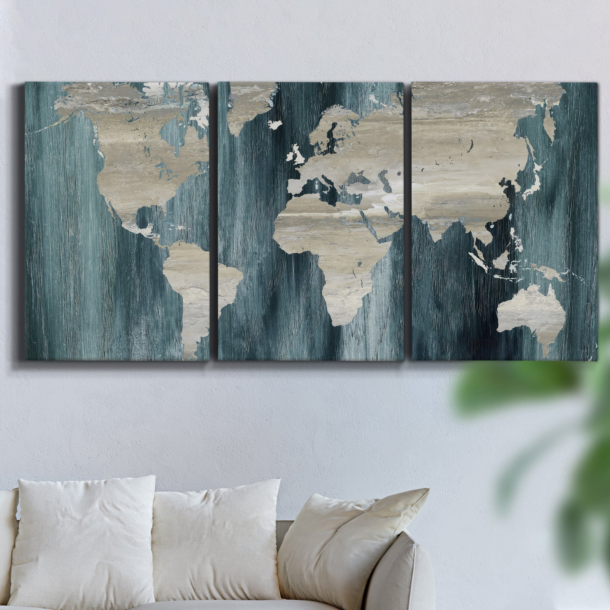 Three-panel canvas wall art featuring golden coastal sunset with cliffs, displayed in a living room above a sofa.