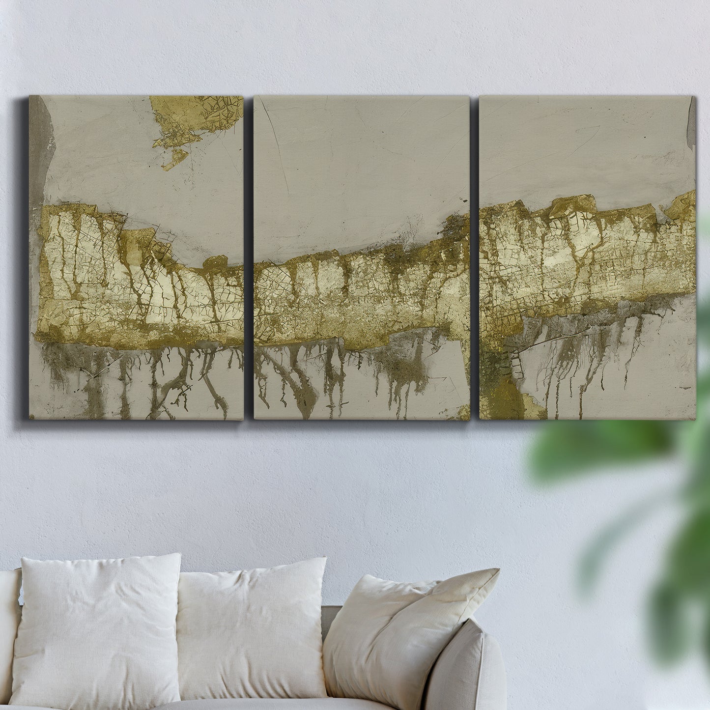Three-panel canvas wall art featuring gold accented abstract ravine, displayed in a living room above a sofa.