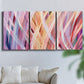 Three-panel canvas wall art featuring layered modern abstract color ribbons, displayed in a living room above a sofa.