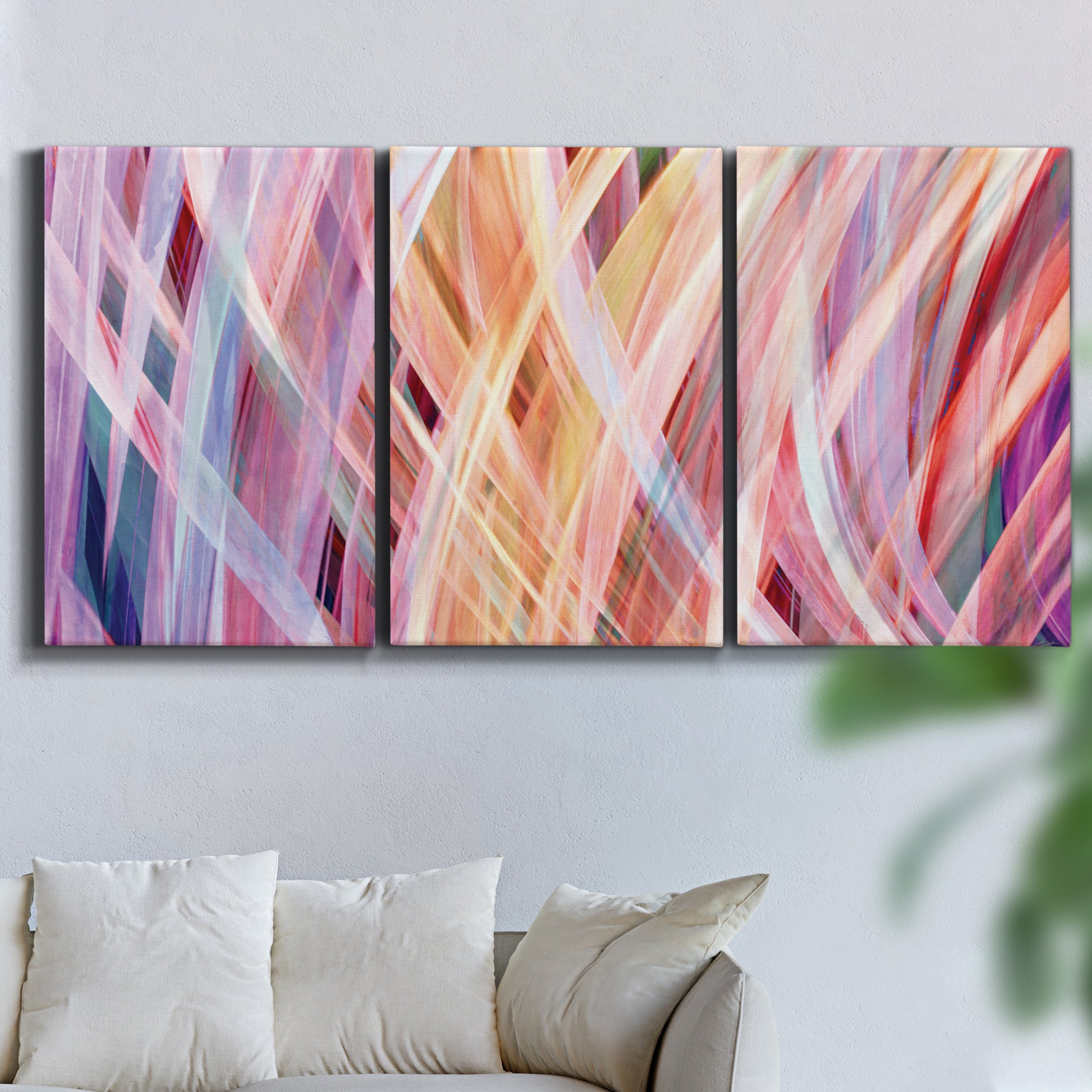 Three-panel canvas wall art featuring layered modern abstract color ribbons, displayed in a living room above a sofa.