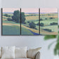 Three-panel canvas wall art featuring pastoral countryside with rocky outcrop, displayed in a living room above a sofa.