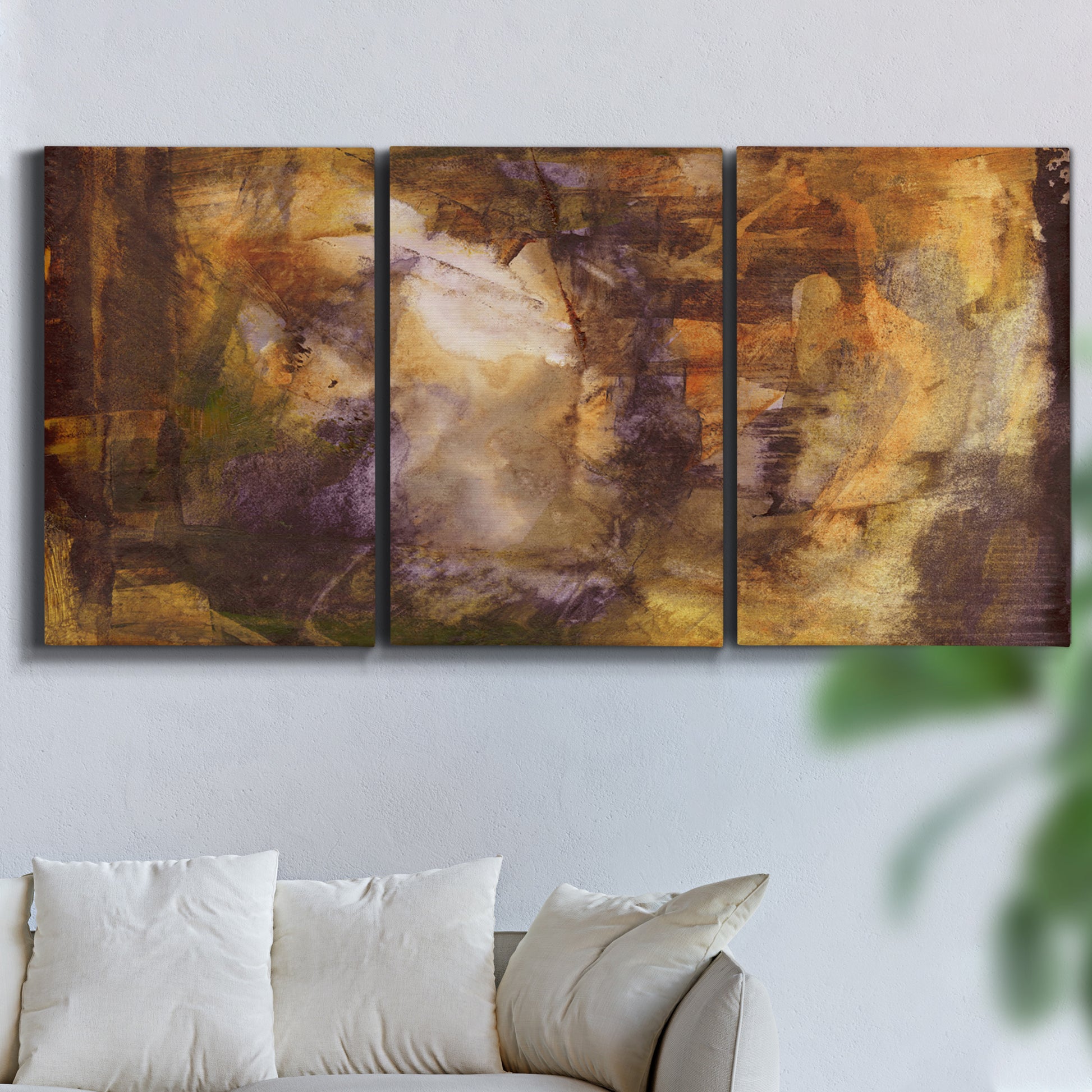 Three-panel canvas wall art featuring abstract architectural landscape, displayed in a living room above a sofa.