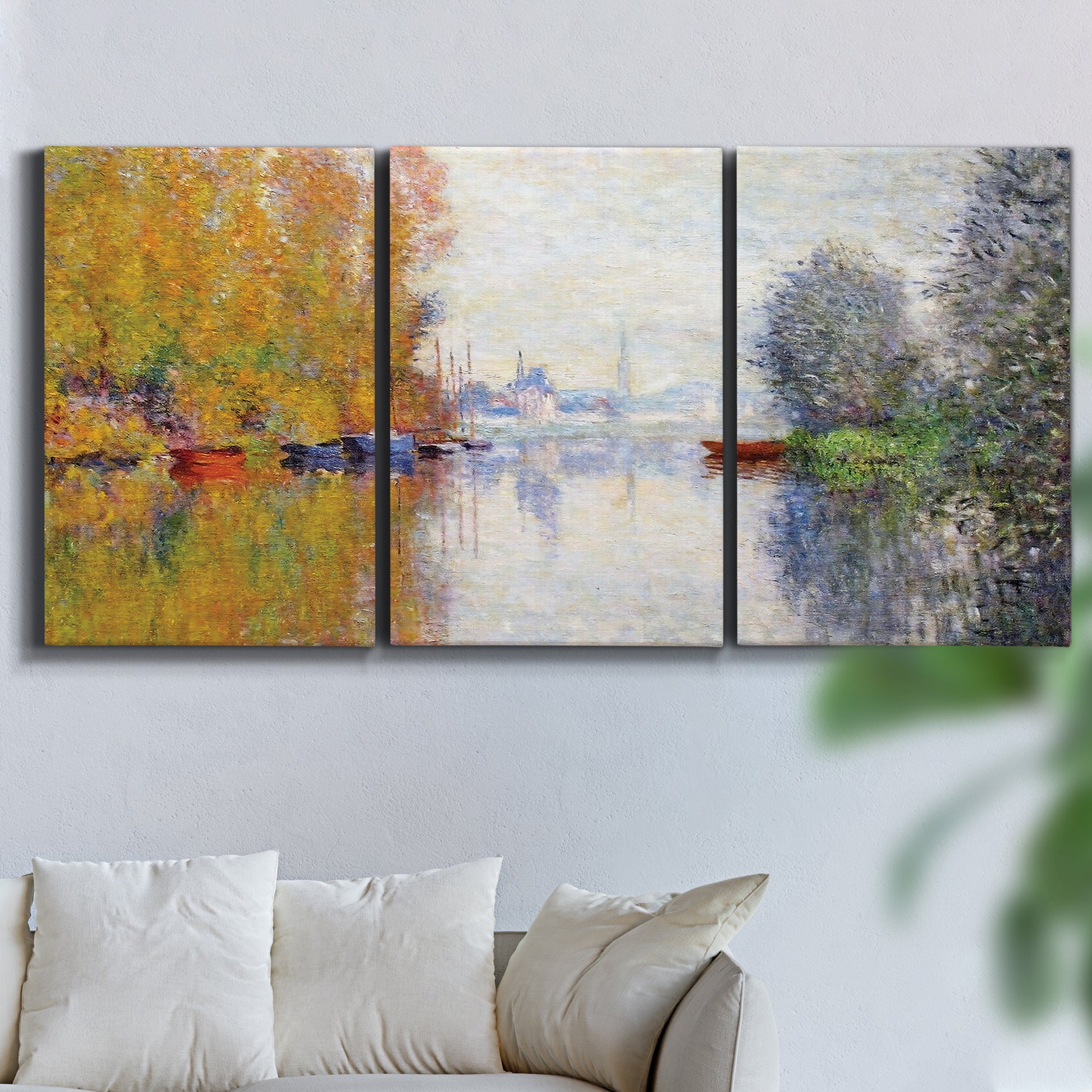 Three-panel canvas wall art featuring golden autumn light over riverside, displayed in a living room above a sofa.