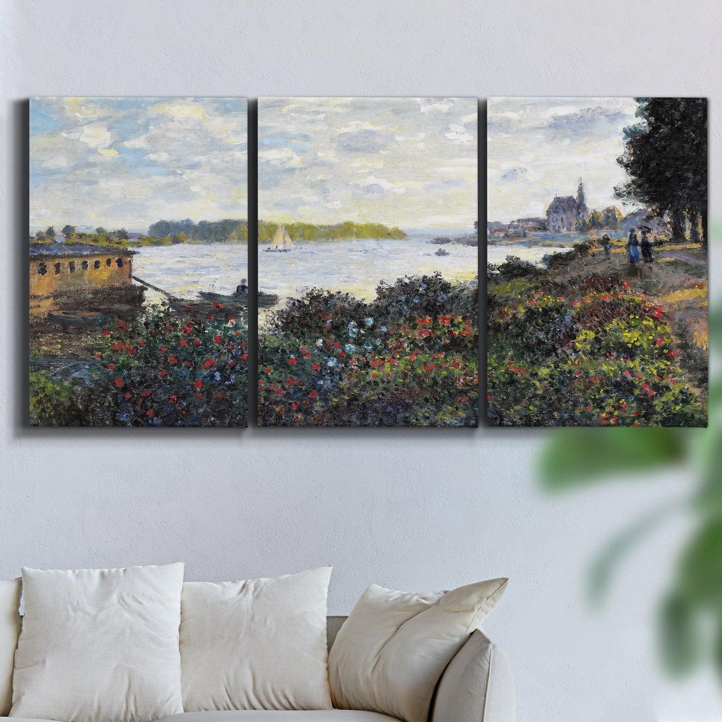 Three-panel canvas wall art featuring river with boats and shoreline, displayed in a living room above a sofa.