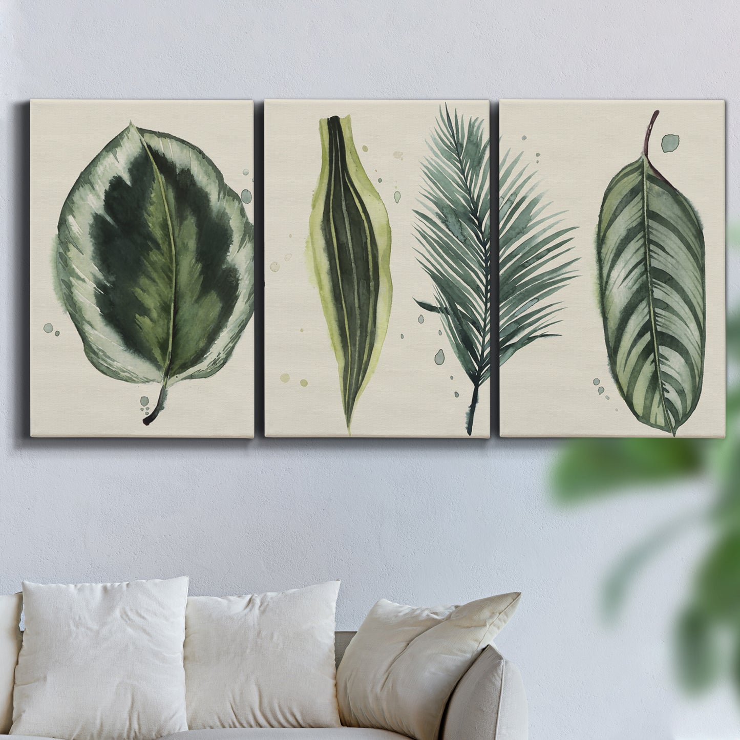 Three-panel canvas wall art featuring botanical palm leaf illustration, displayed in a living room above a sofa.