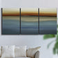 Three-panel canvas wall art featuring horizontal abstract coastal color bands, displayed in a living room above a sofa.
