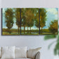 Three-panel canvas wall art featuring tall trees lining open landscape, displayed in a living room above a sofa.