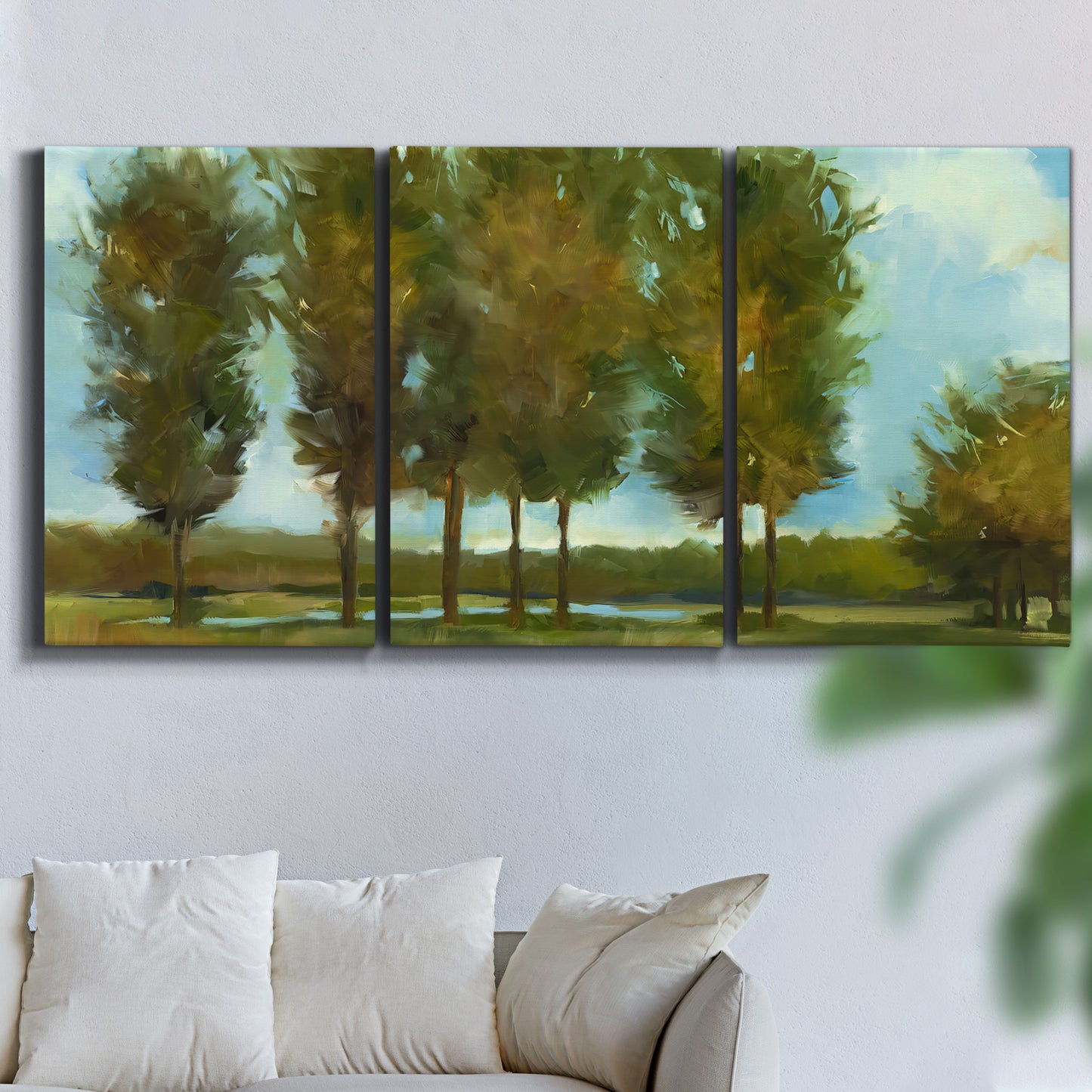 Three-panel canvas wall art featuring tall trees lining open landscape, displayed in a living room above a sofa.