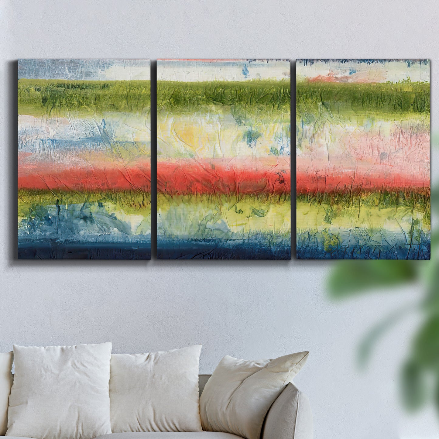Three-panel canvas wall art featuring layered abstract color banding, displayed in a living room above a sofa.