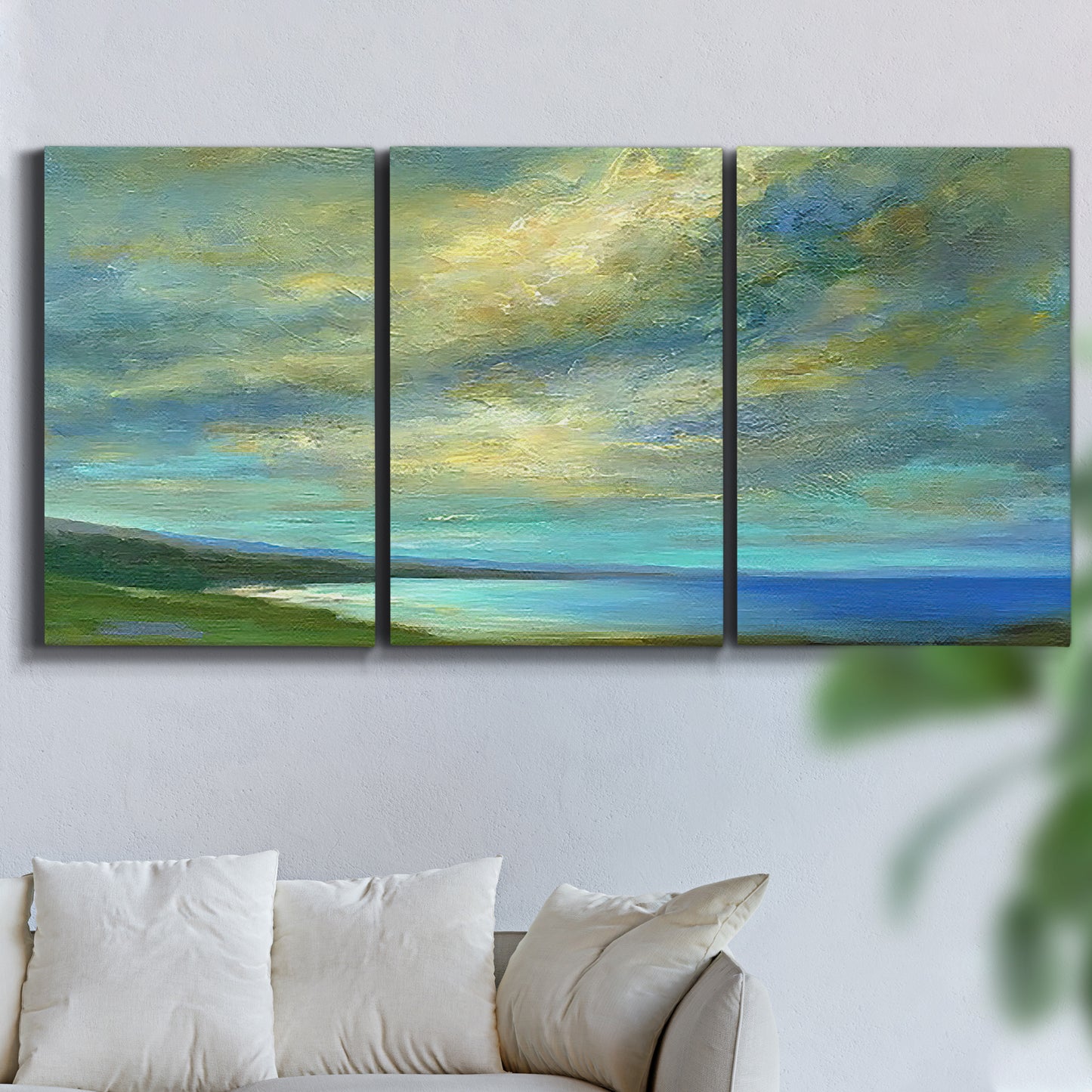Three-panel canvas wall art featuring coastal shoreline with soft waves, displayed in a living room above a sofa.