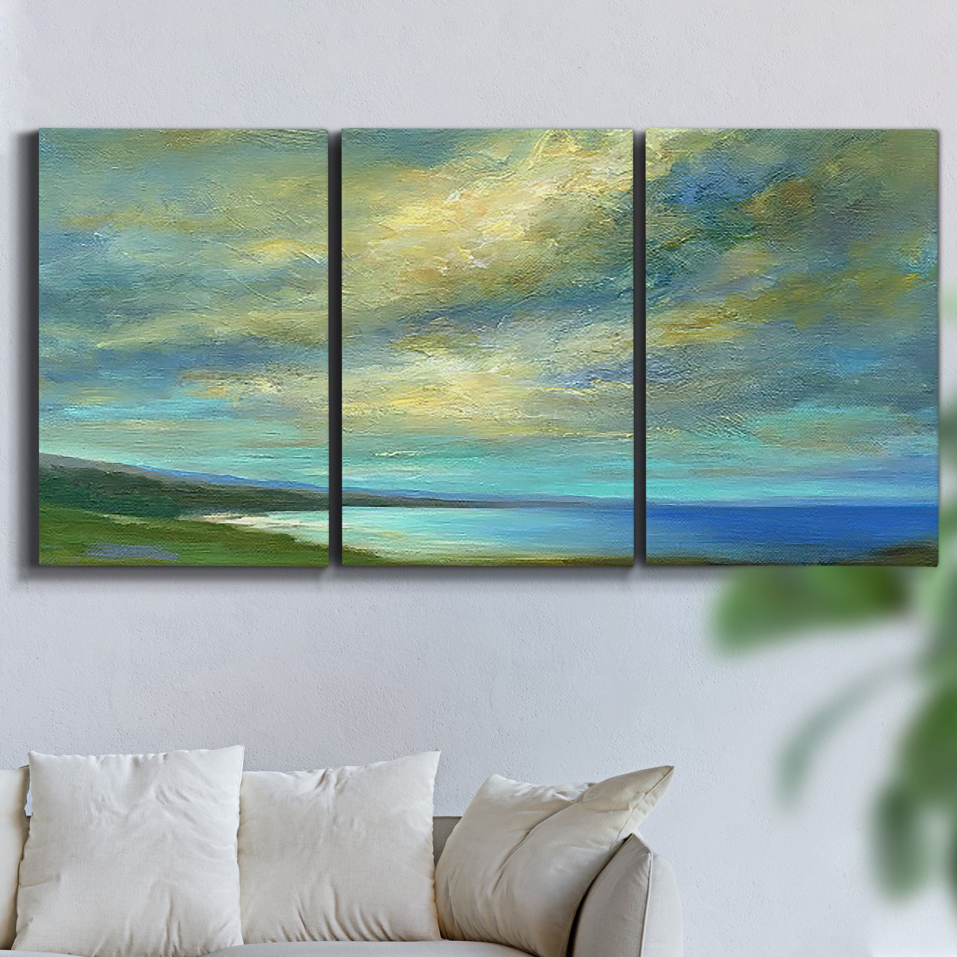 Three-panel canvas wall art featuring coastal shoreline with soft waves, displayed in a living room above a sofa.