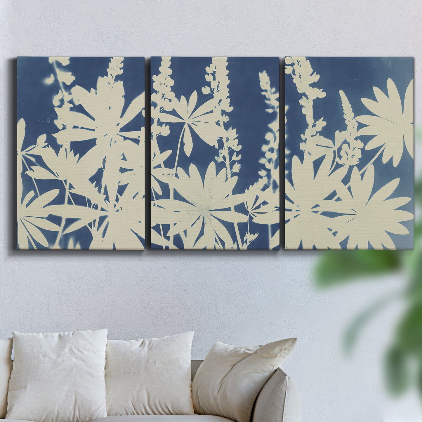 Three-panel canvas wall art featuring delicate lupine floral composition, displayed in a living room above a sofa.