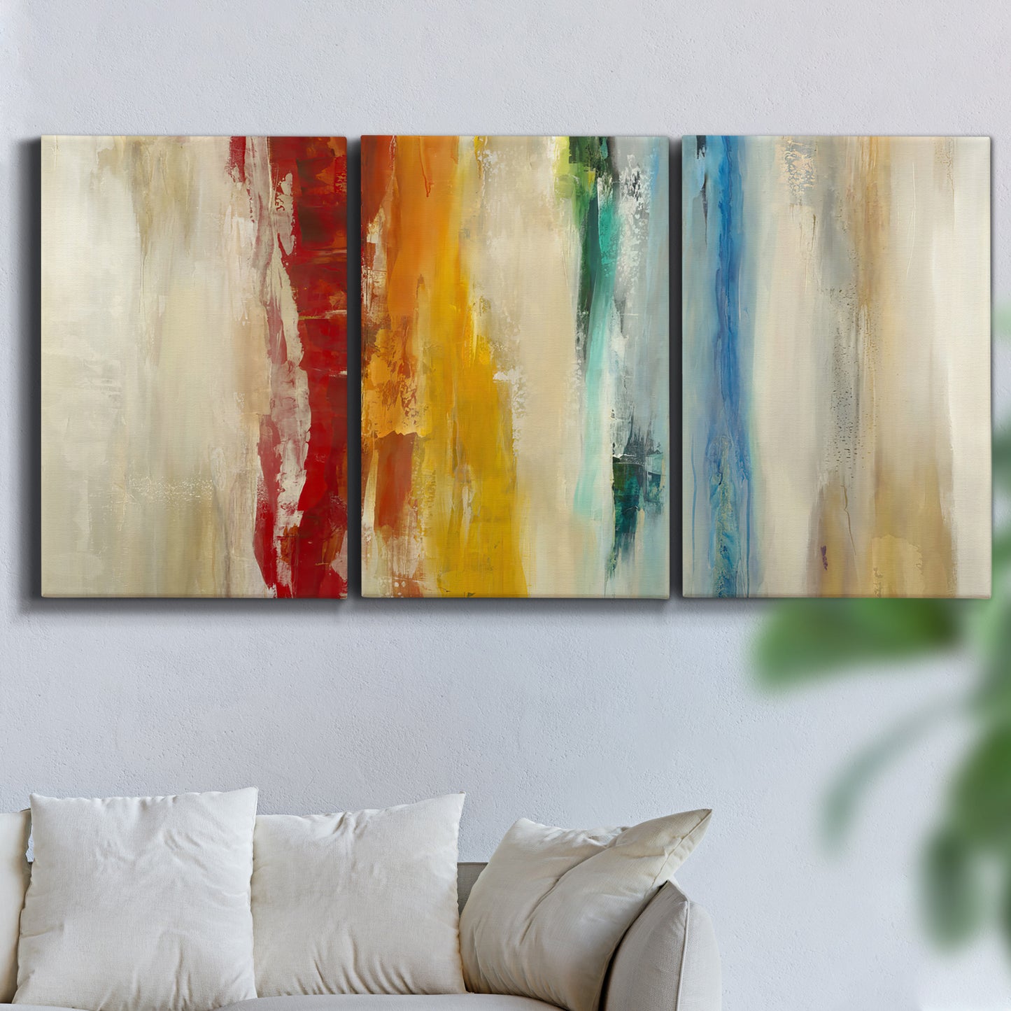 Three-panel canvas wall art featuring abstract divided color hemisphere forms, displayed in a living room above a sofa.