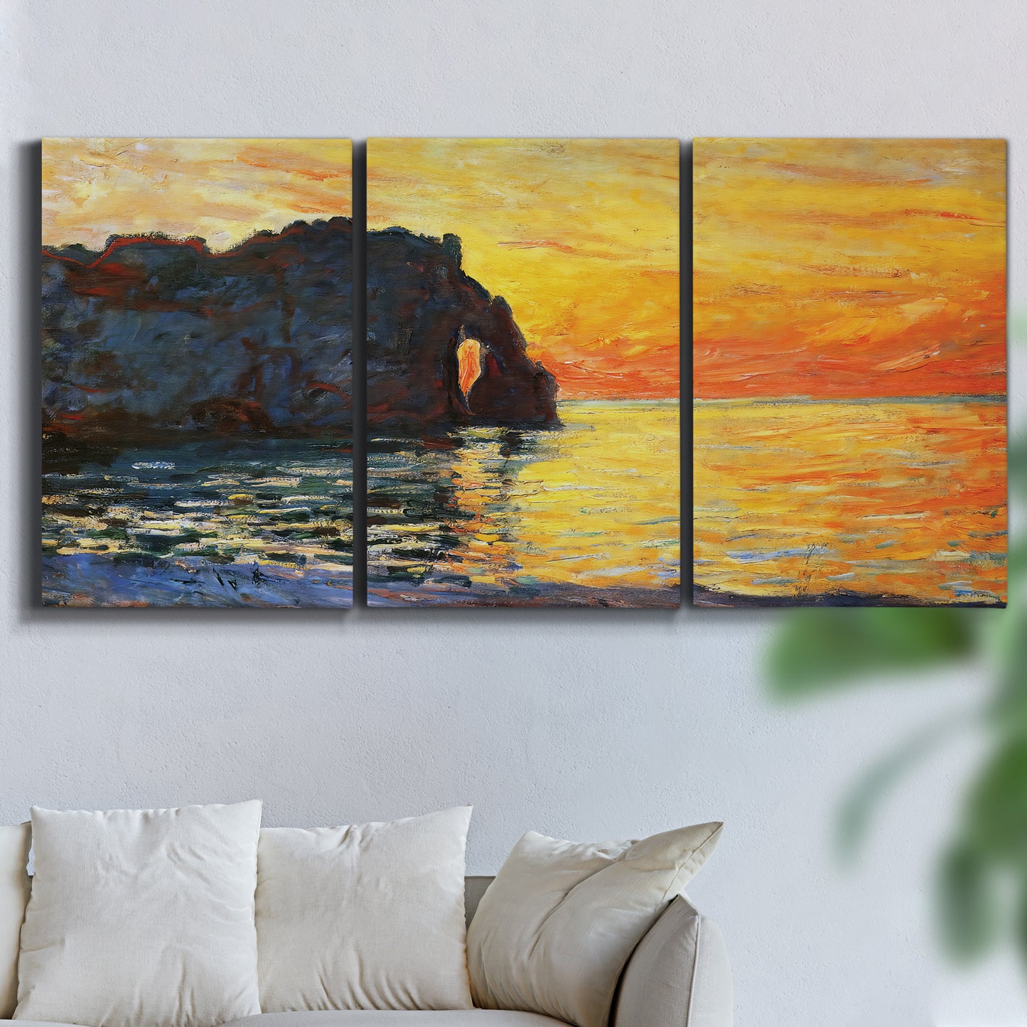 Three-panel canvas wall art featuring arched coastal cliff above sea, displayed in a living room above a sofa.