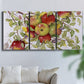 Three-panel canvas wall art featuring apples hanging from branch, displayed in a living room above a sofa.