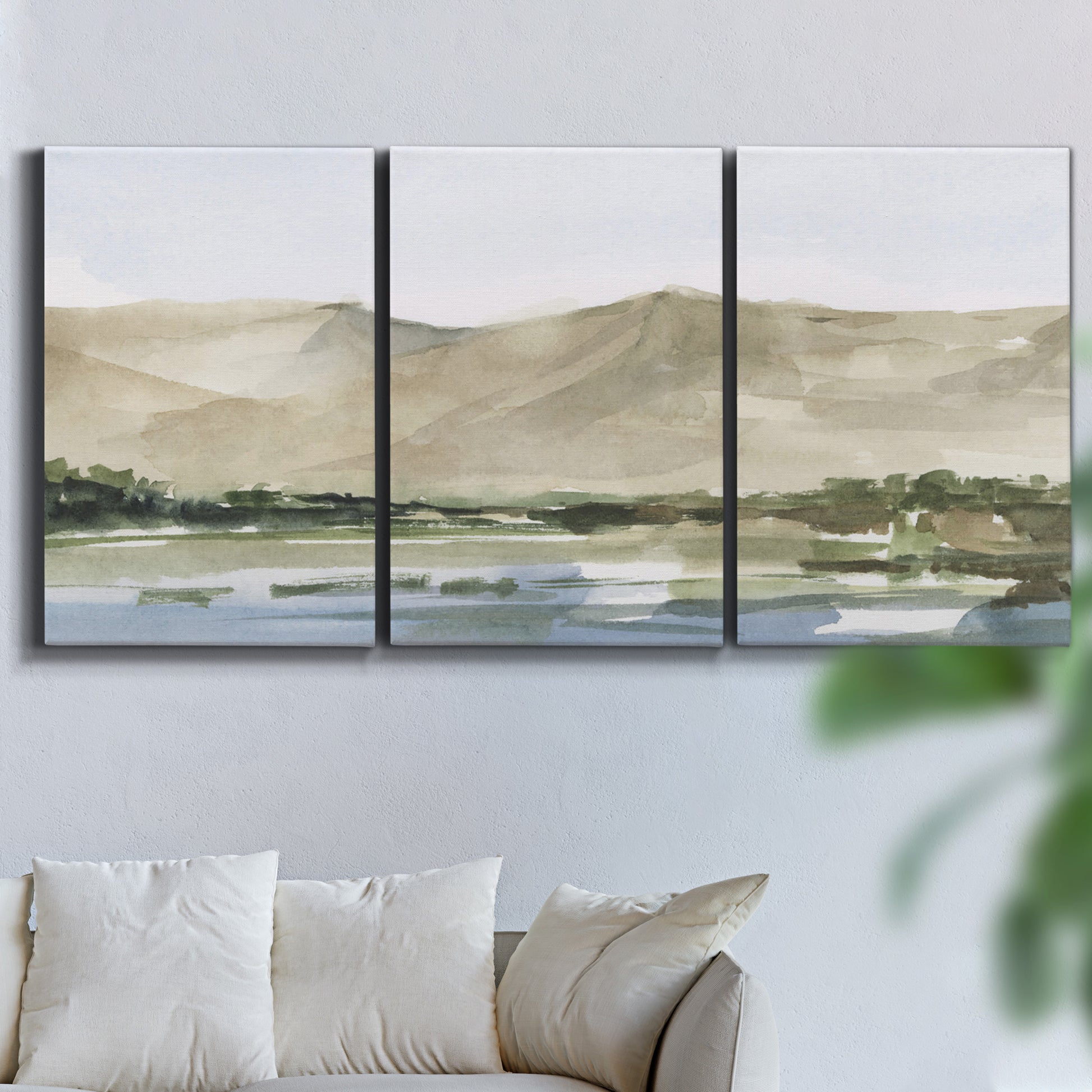 Three-panel canvas wall art featuring desert mountain landscape watercolor, displayed in a living room above a sofa.