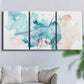 Three-panel canvas wall art featuring soft abstract watercolor forms, displayed in a living room above a sofa.
