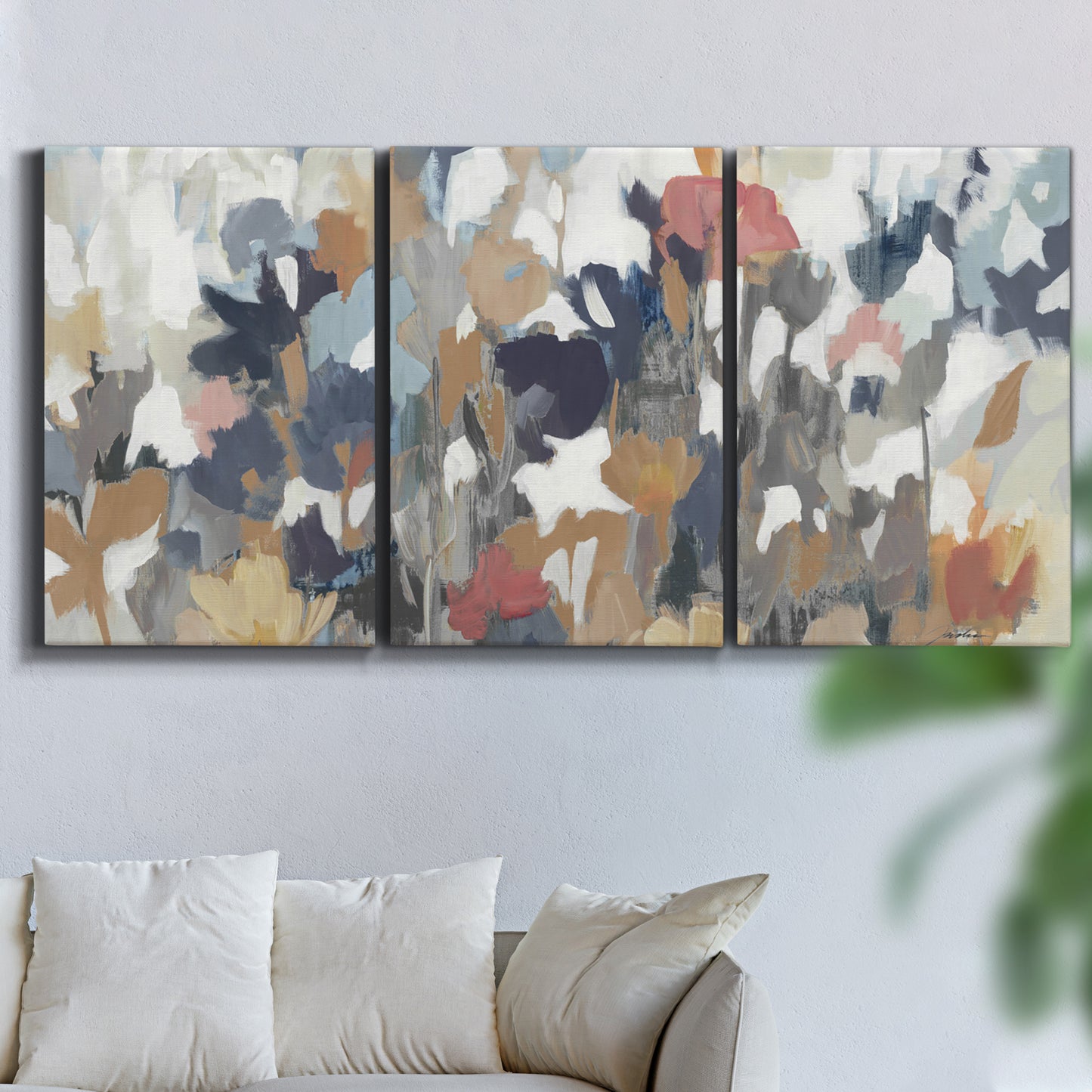 Three-panel canvas wall art featuring abstract flower stand composition, displayed in a living room above a sofa.