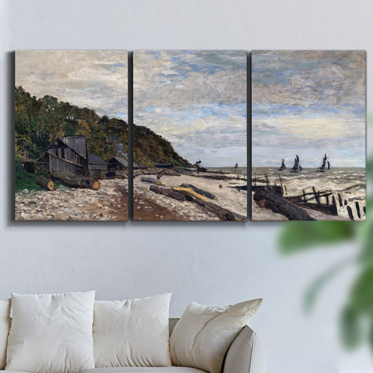 Three-panel canvas wall art featuring open sea along rocky shore, displayed in a living room above a sofa.