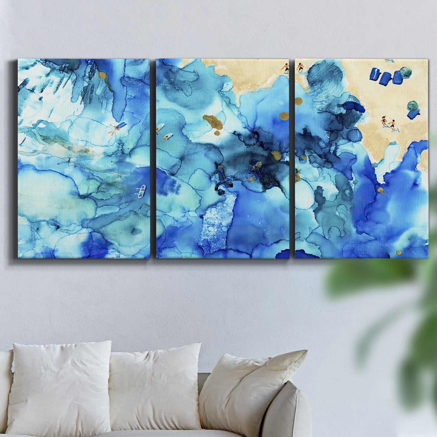 Three-panel canvas wall art featuring abstract coastal beach color fields, displayed in a living room above a sofa.