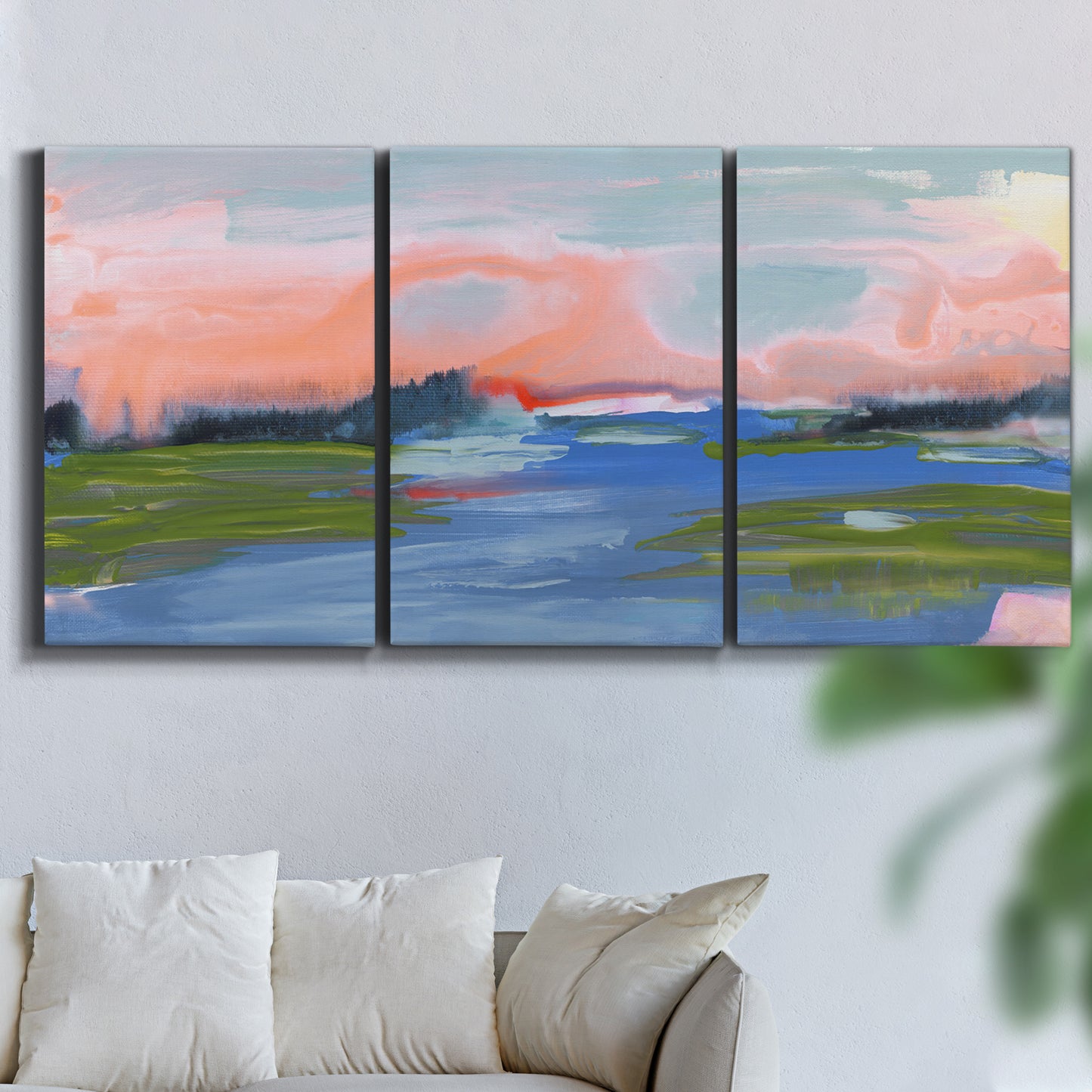 Three-panel canvas wall art featuring sunset reflections across calm sea, displayed in a living room above a sofa.