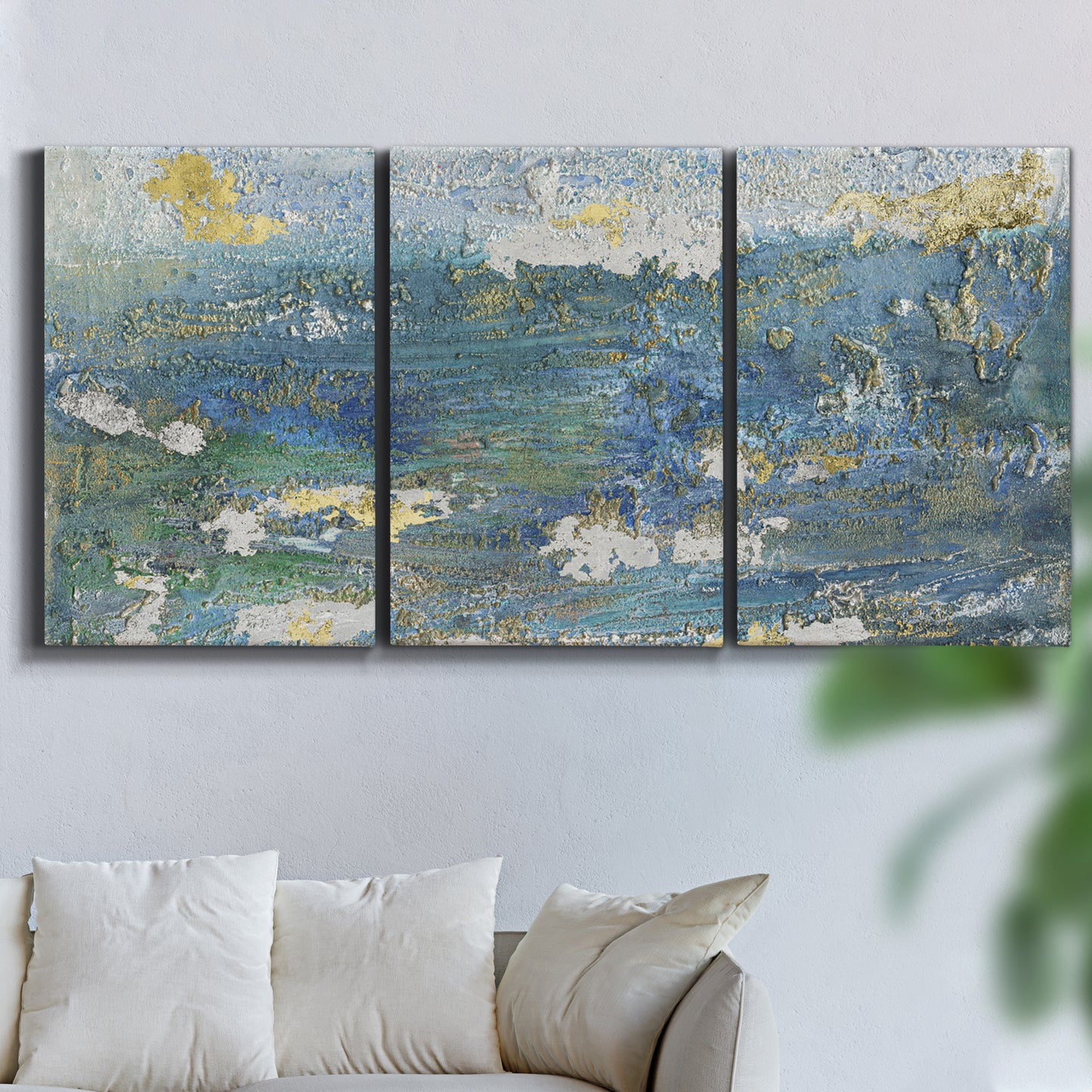 Three-panel canvas wall art featuring sparkling abstract sea surface, displayed in a living room above a sofa.