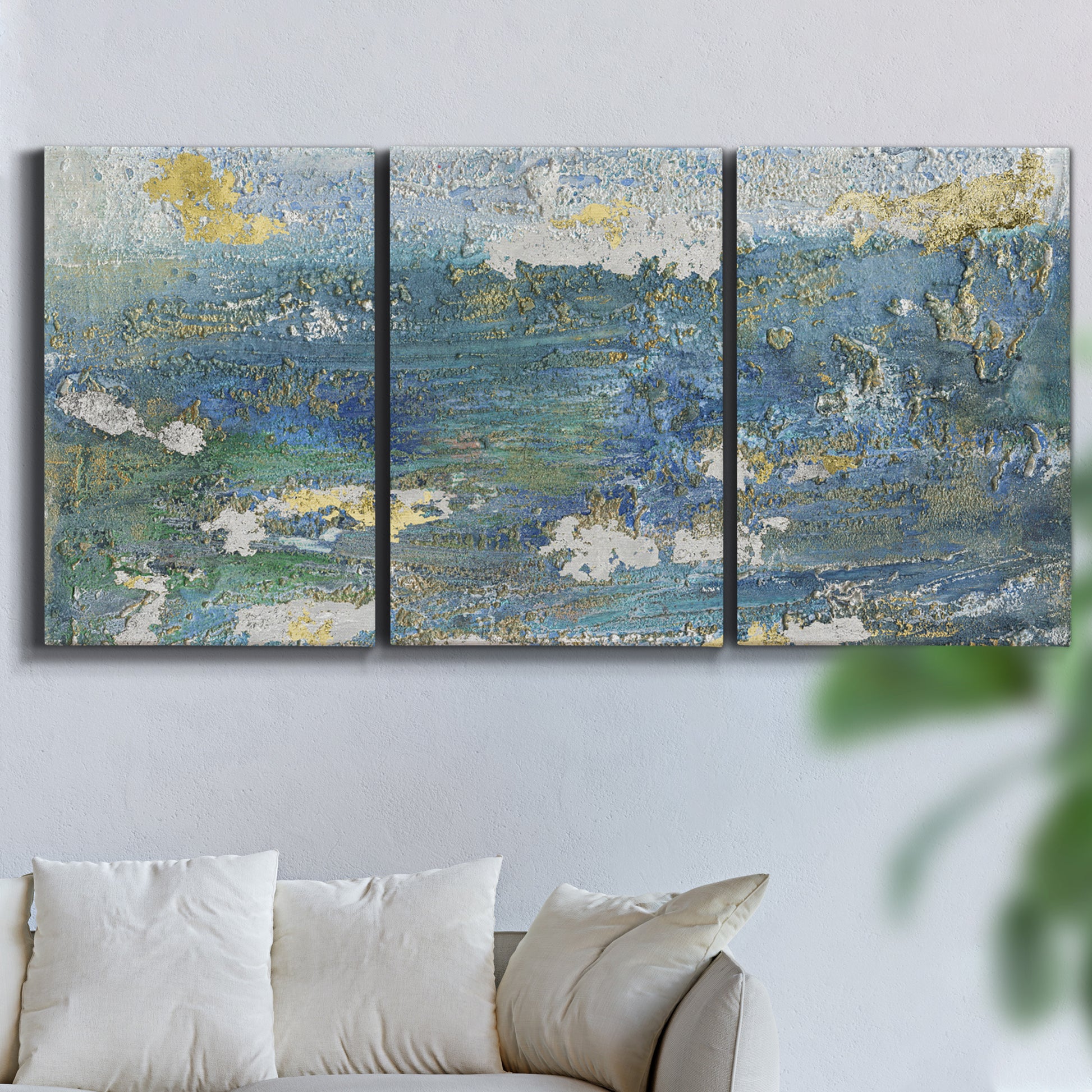 Three-panel canvas wall art featuring sparkling abstract sea surface, displayed in a living room above a sofa.