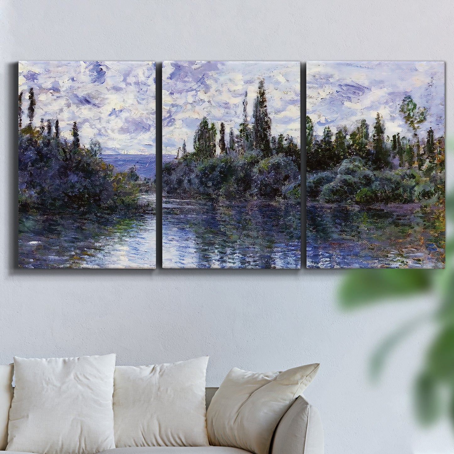 Three-panel canvas wall art featuring quiet river bend near village, displayed in a living room above a sofa.