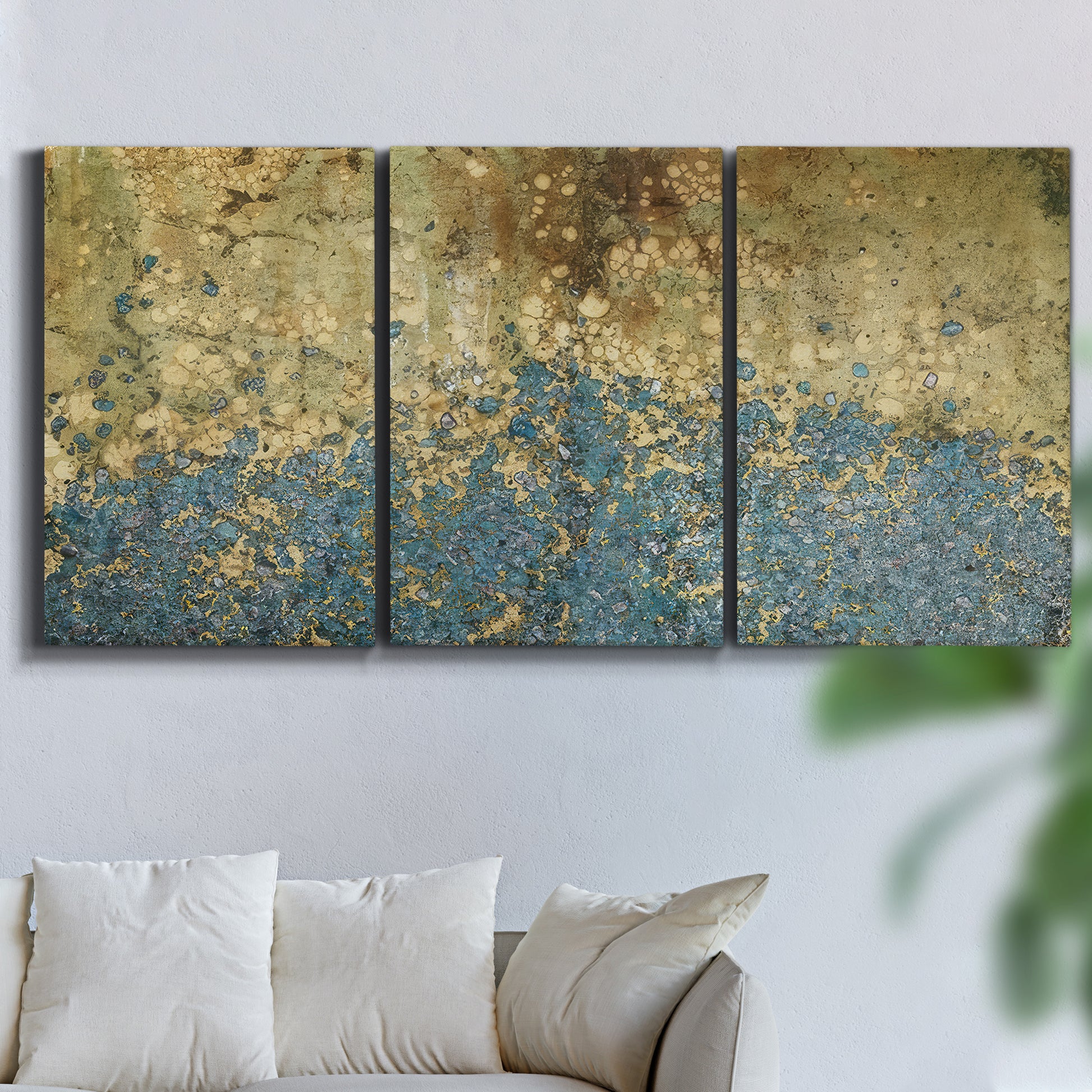 Three-panel canvas wall art featuring metallic abstract gold tones, displayed in a living room above a sofa.