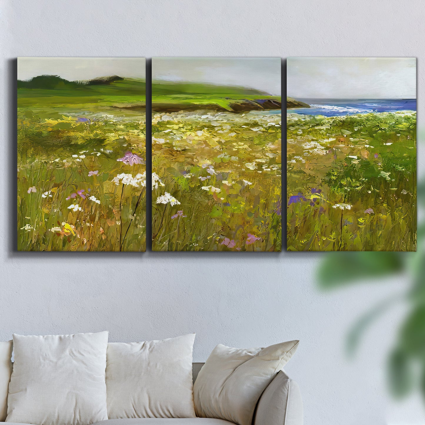 Three-panel canvas wall art featuring rugged coastal cliff landscape, displayed in a living room above a sofa.