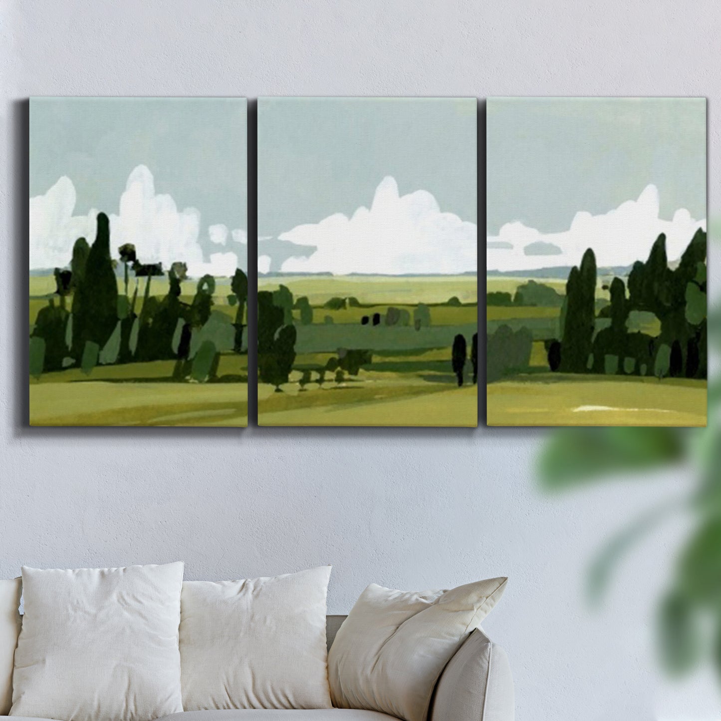 Three-panel canvas wall art featuring lush green summer countryside, displayed in a living room above a sofa.
