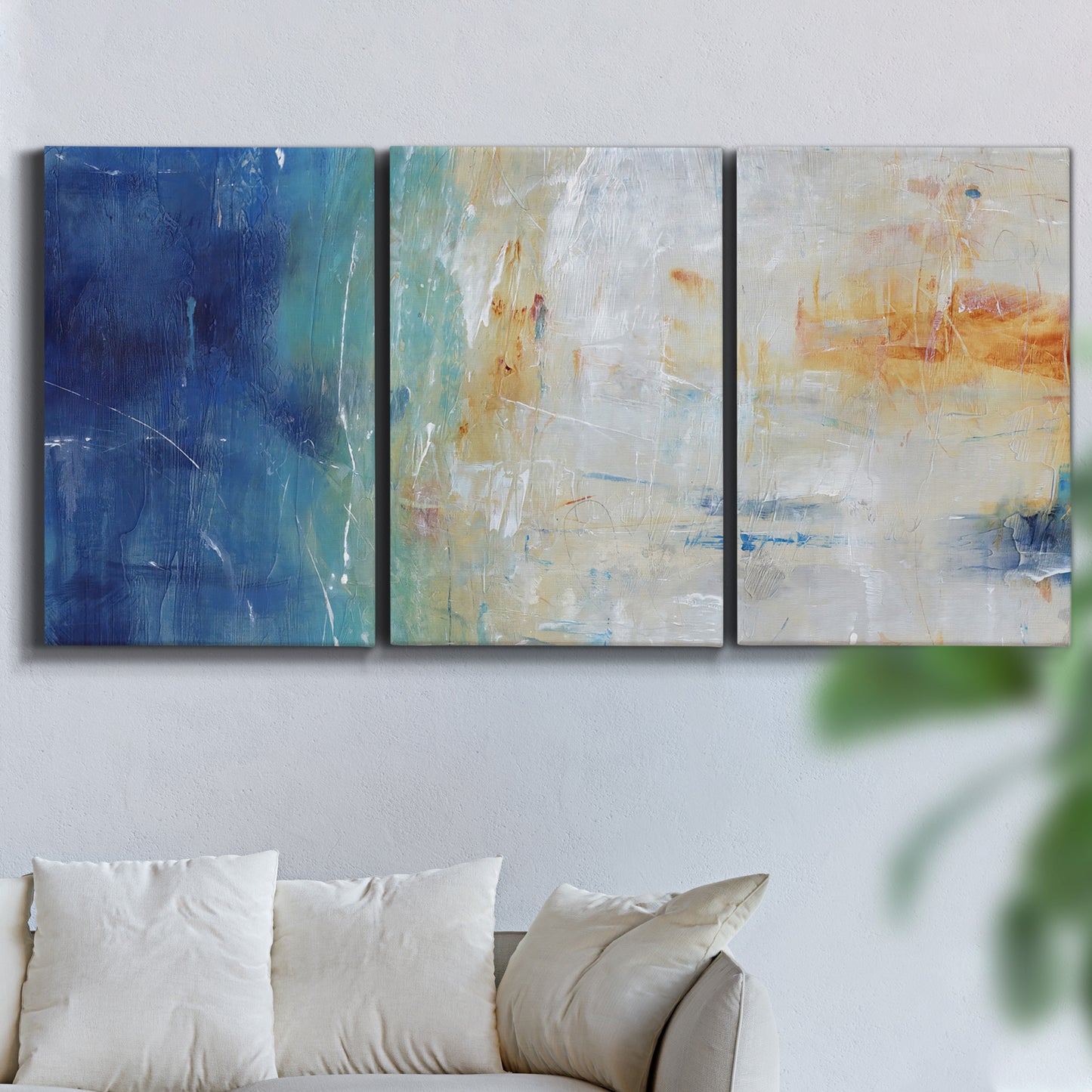 Three-panel canvas wall art featuring deep blue abstract grotto tones, displayed in a living room above a sofa.
