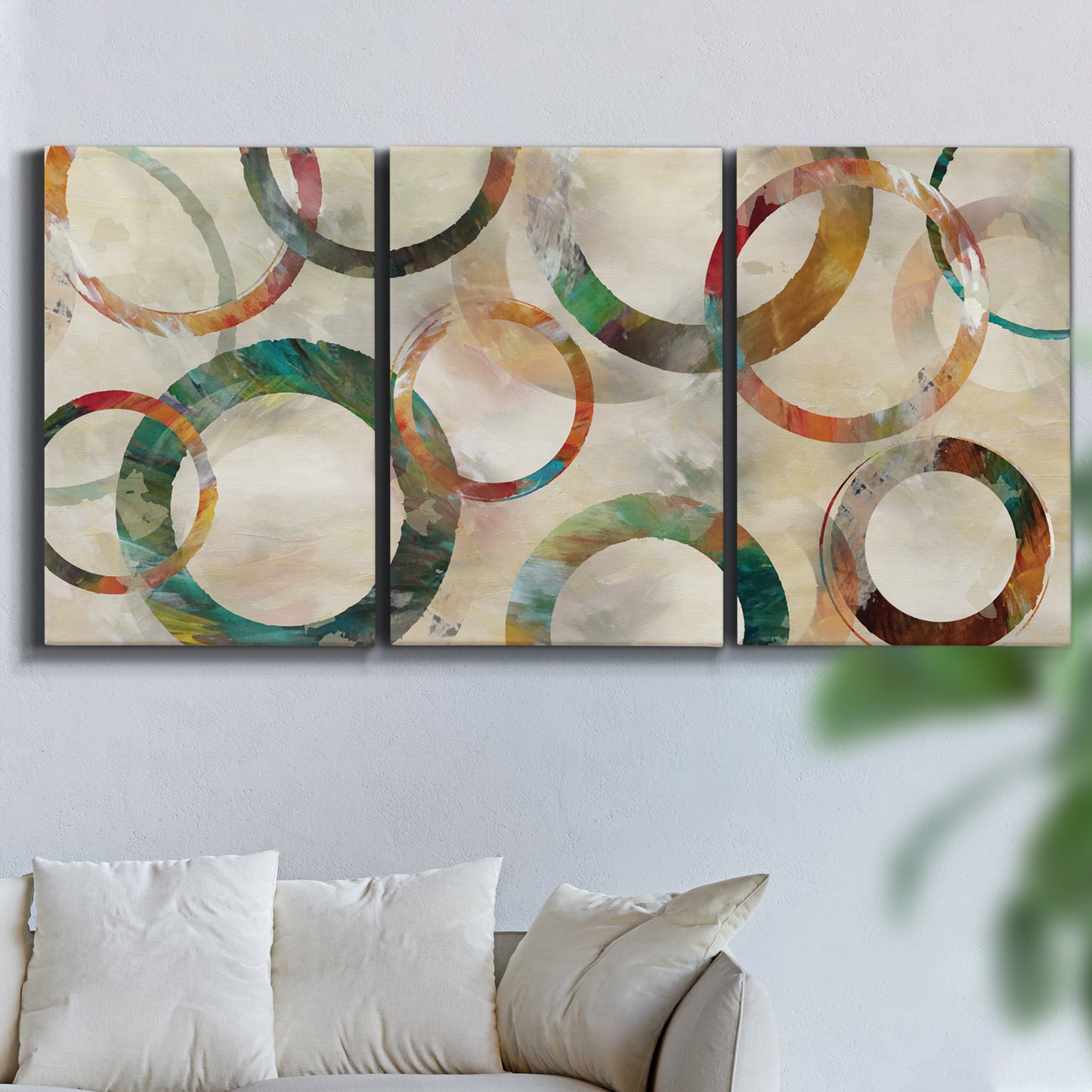 Three-panel canvas wall art featuring geometric circular abstract design, displayed in a living room above a sofa.