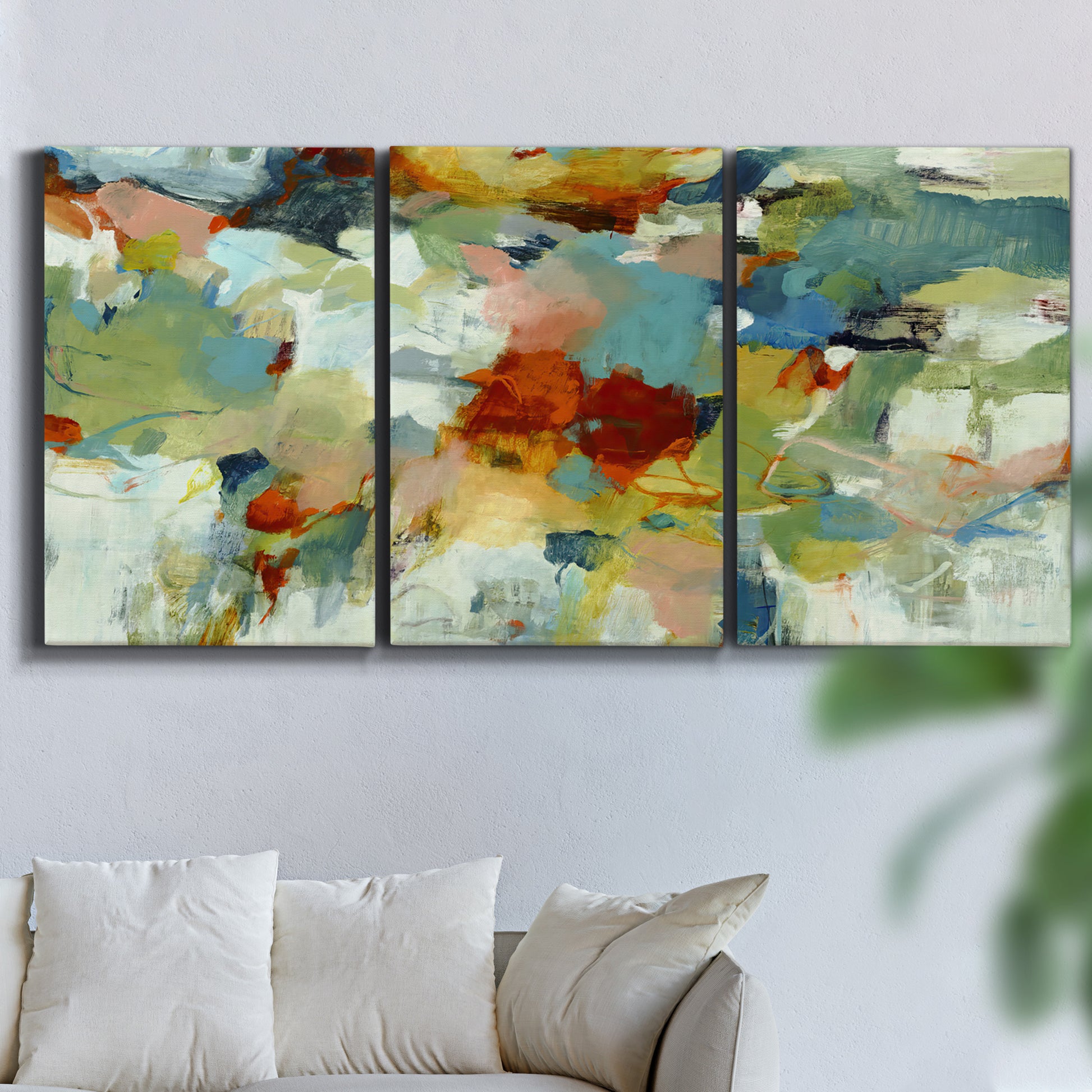 Three-panel canvas wall art featuring celebratory abstract color movement, displayed in a living room above a sofa.