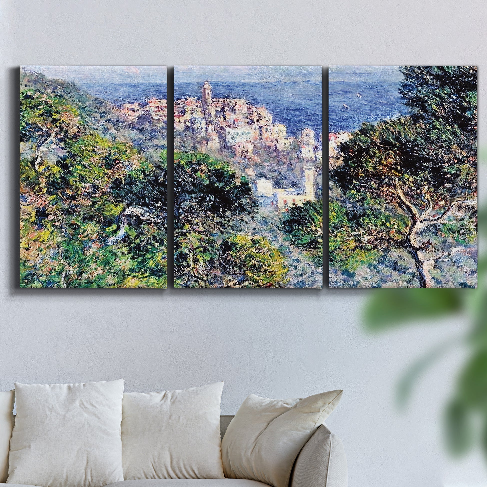 Three-panel canvas wall art featuring coastal hillside overlooking monaco, displayed in a living room above a sofa.
