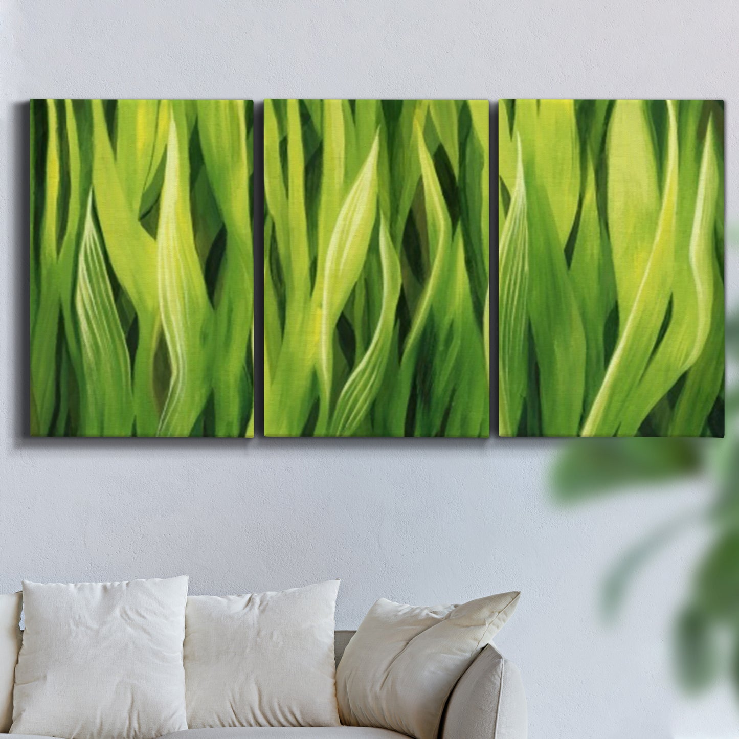 Three-panel canvas wall art featuring close view of tall green grass blades, displayed in a living room above a sofa.