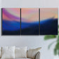 Three-panel canvas wall art featuring smooth abstract sunset color gradient, displayed in a living room above a sofa.