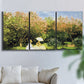 Three-panel canvas wall art featuring lush garden landscape with trees, displayed in a living room above a sofa.