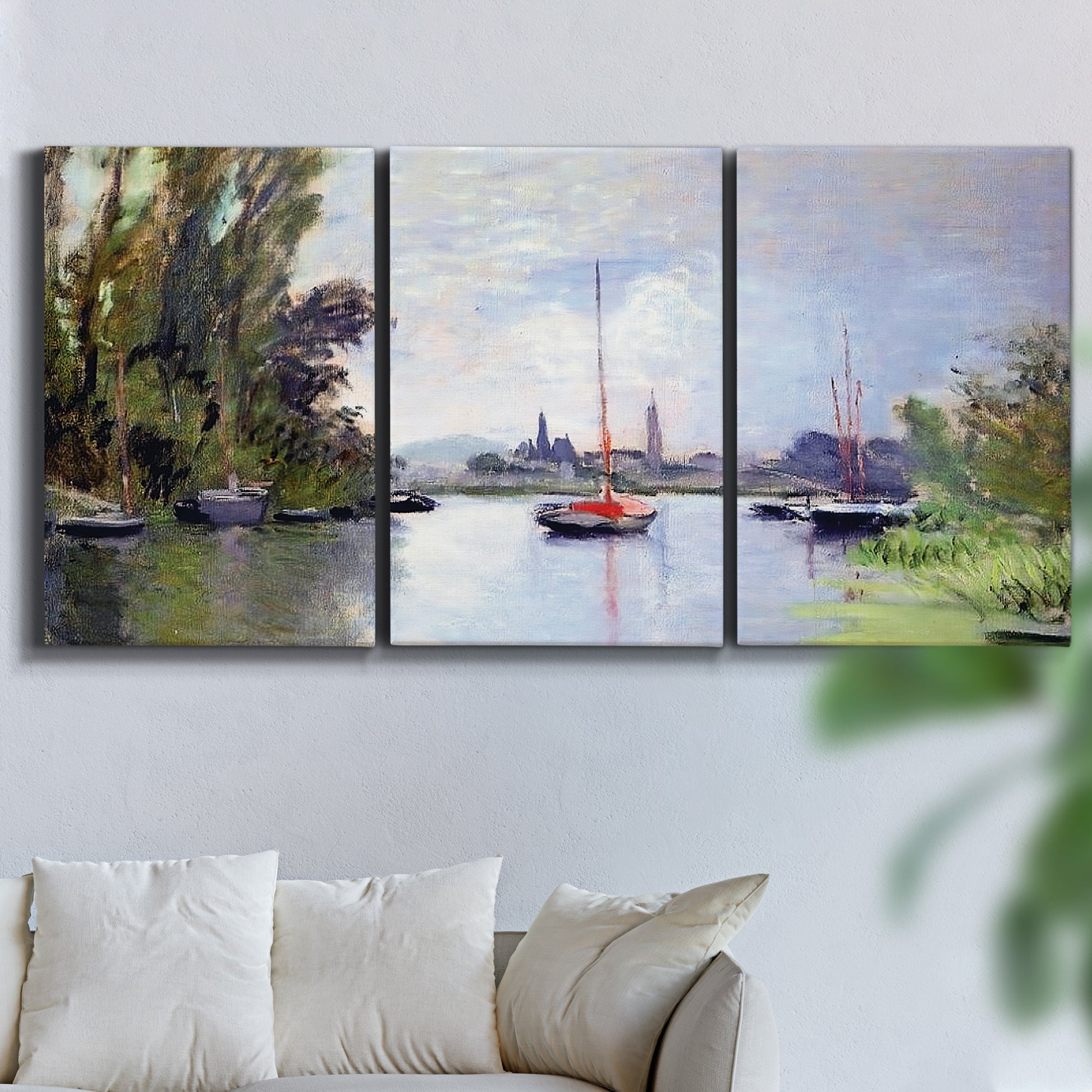 Three-panel canvas wall art featuring river view with boats and reflections, displayed in a living room above a sofa.