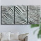 Three-panel canvas wall art featuring coastal shoreline with gentle surf, displayed in a living room above a sofa.