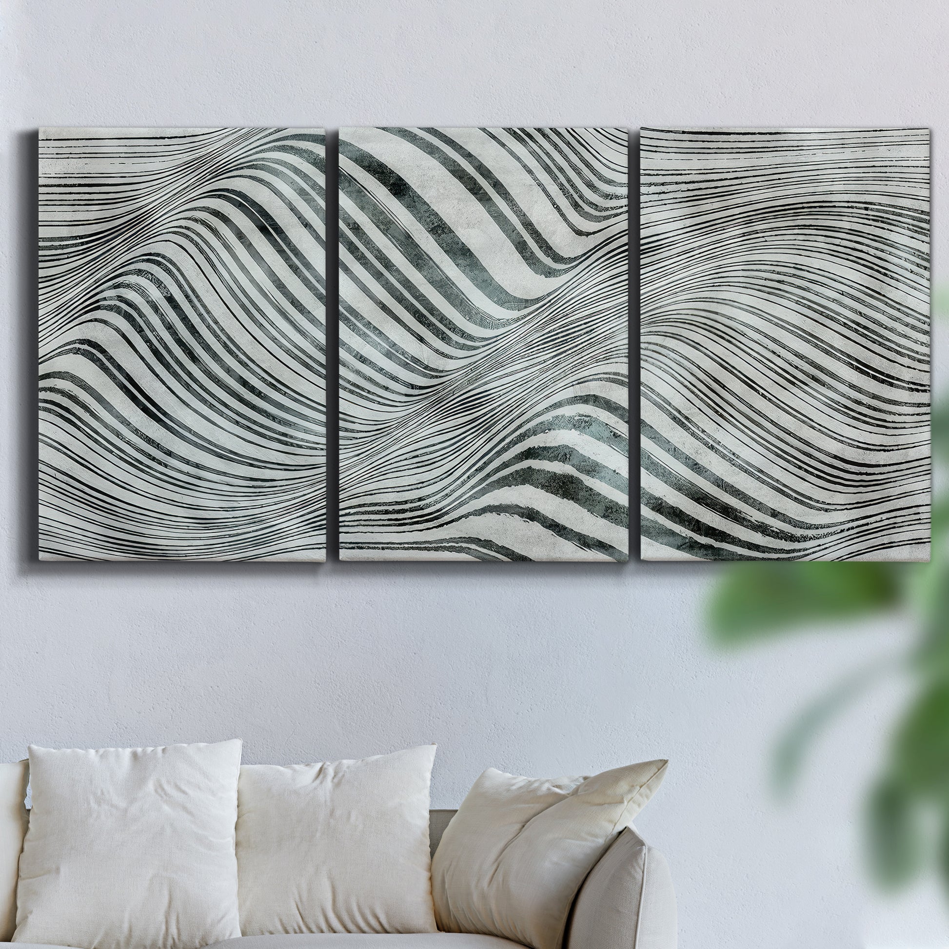 Three-panel canvas wall art featuring coastal shoreline with gentle surf, displayed in a living room above a sofa.