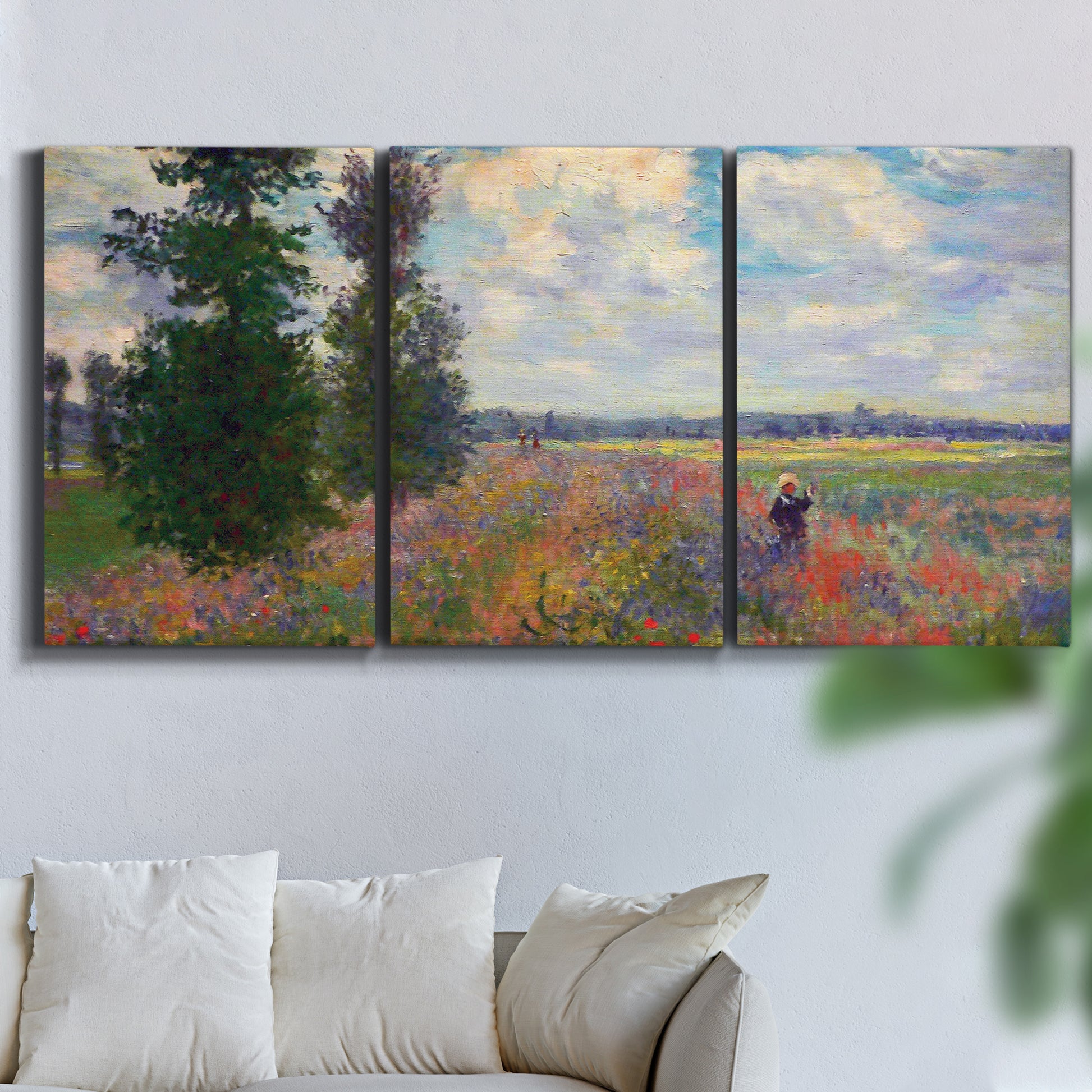 Three-panel canvas wall art featuring poppy field in open countryside, displayed in a living room above a sofa.