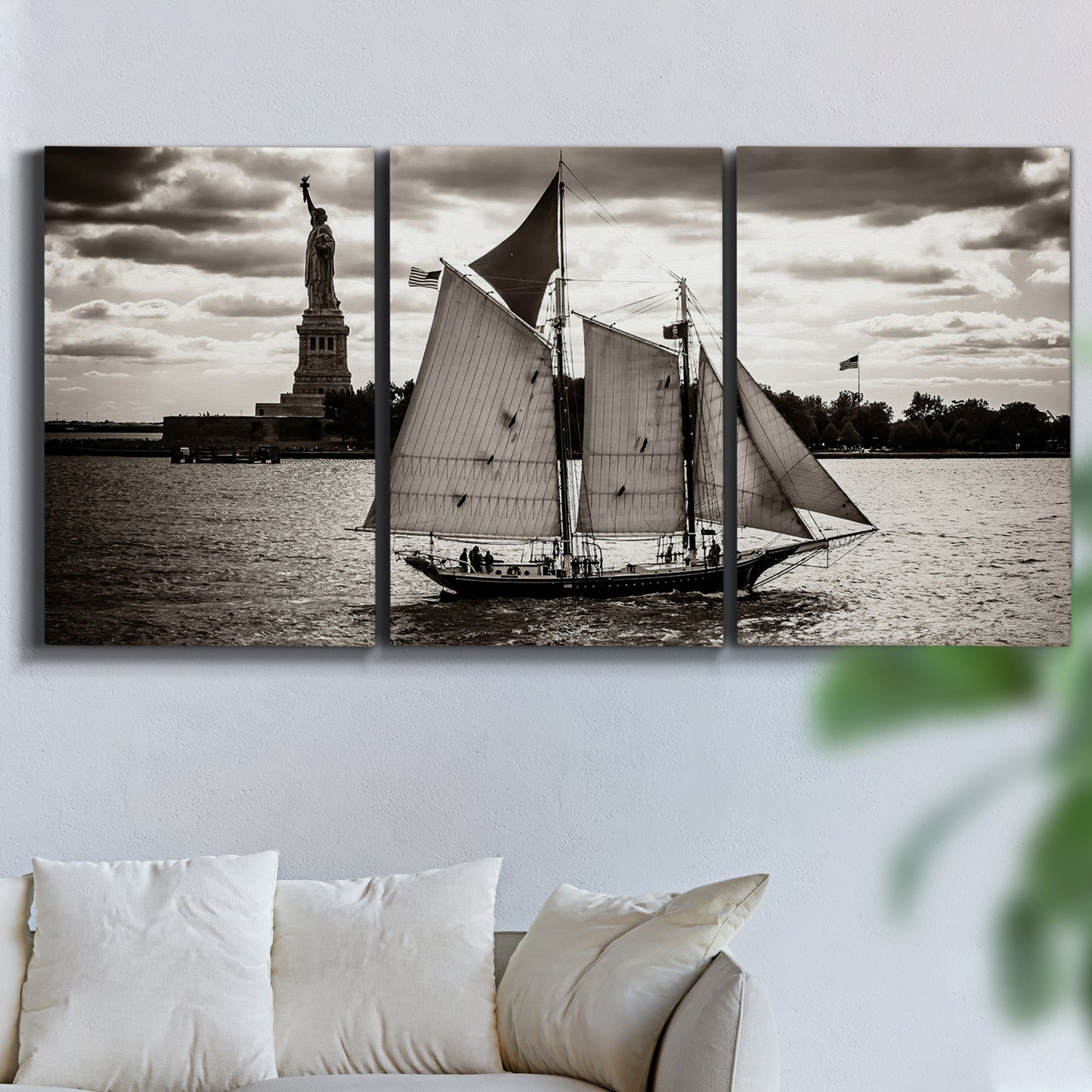 Three-panel canvas wall art featuring historic sailing ships photograph, displayed in a living room above a sofa.