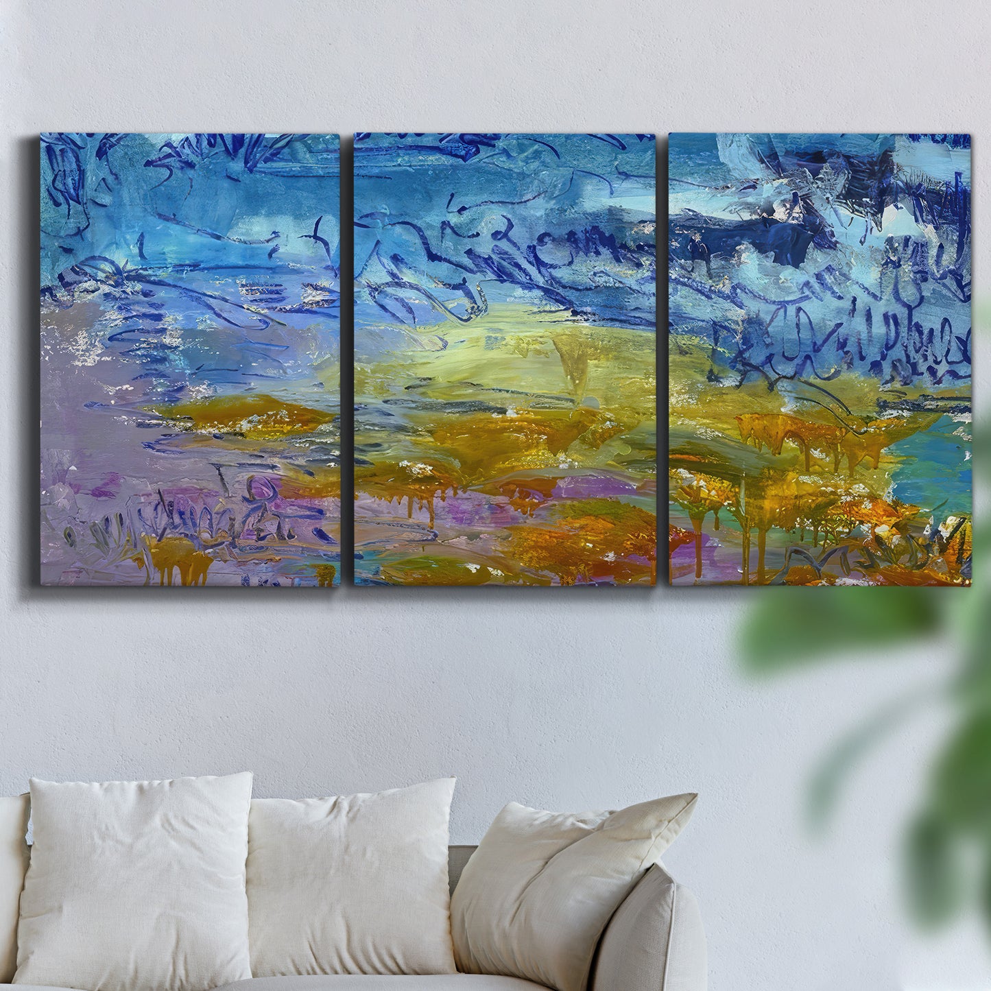 Three-panel canvas wall art featuring expressive abstract with layered color, displayed in a living room above a sofa.