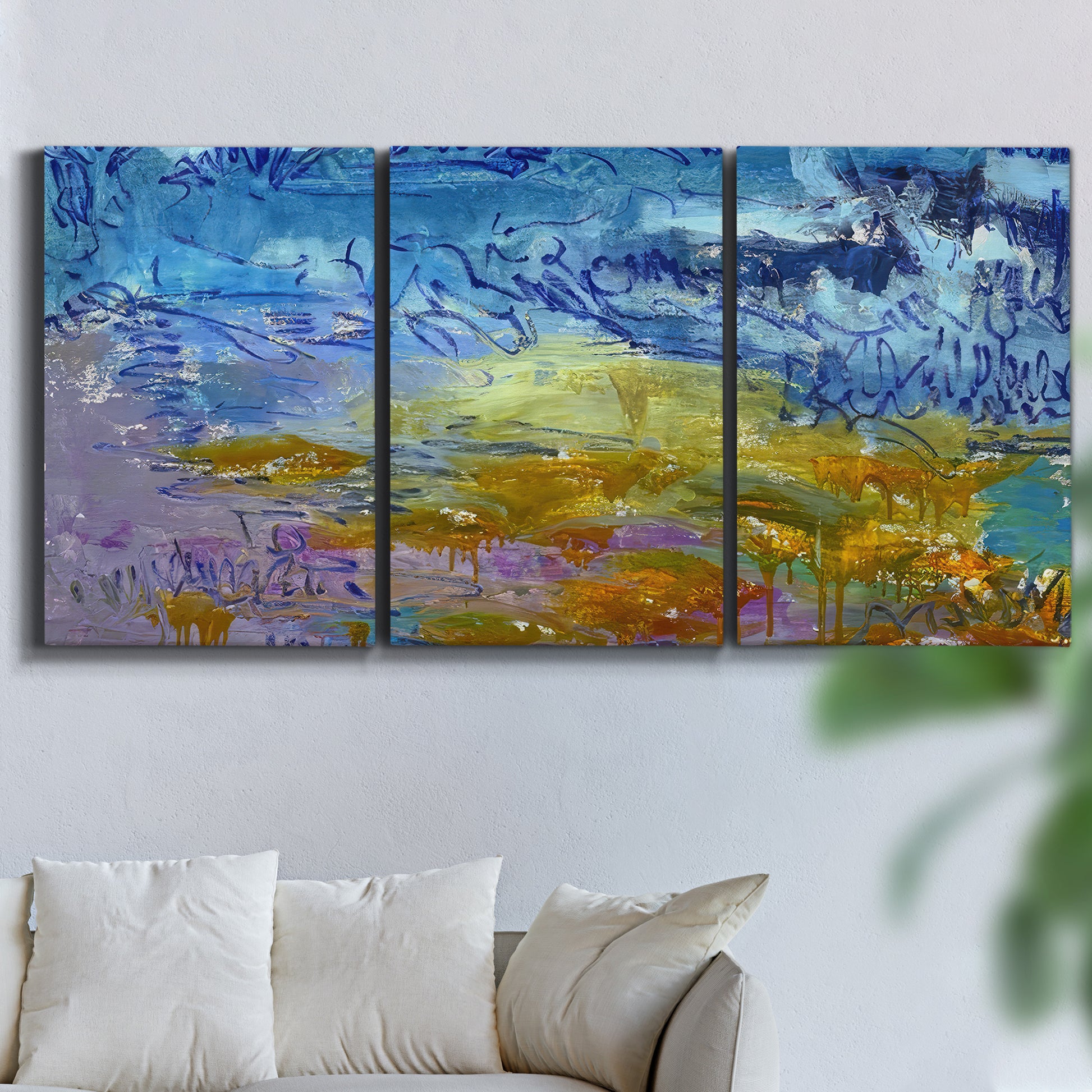 Three-panel canvas wall art featuring expressive abstract with layered color, displayed in a living room above a sofa.