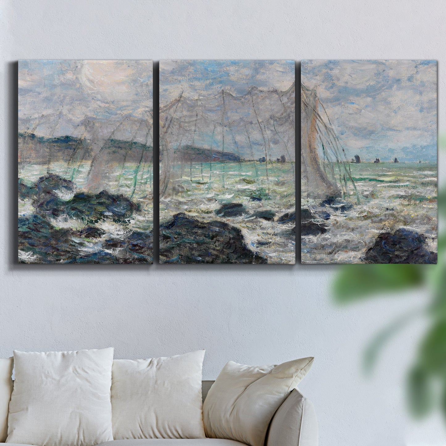 Three-panel canvas wall art featuring rough seas along rocky coast, displayed in a living room above a sofa.
