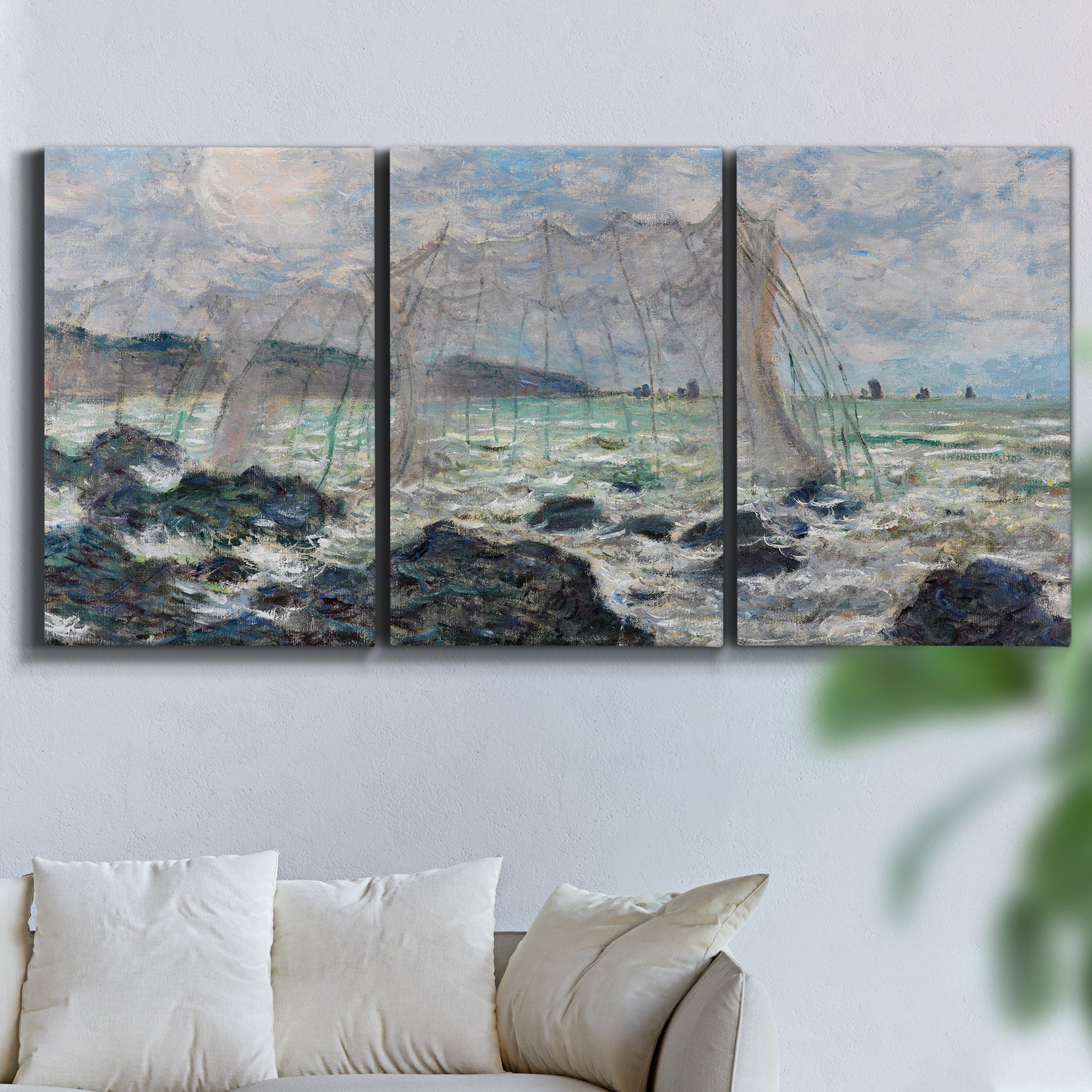 Three-panel canvas wall art featuring rough seas along rocky coast, displayed in a living room above a sofa.
