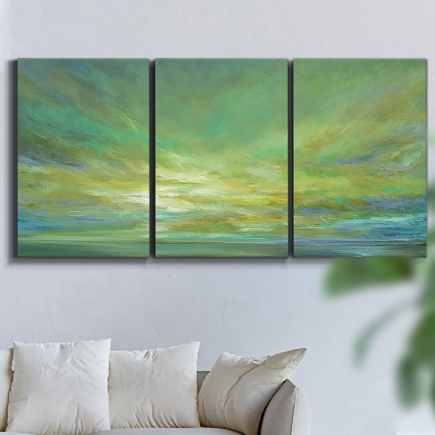Three-panel canvas wall art featuring coastal shoreline under open sky, displayed in a living room above a sofa.