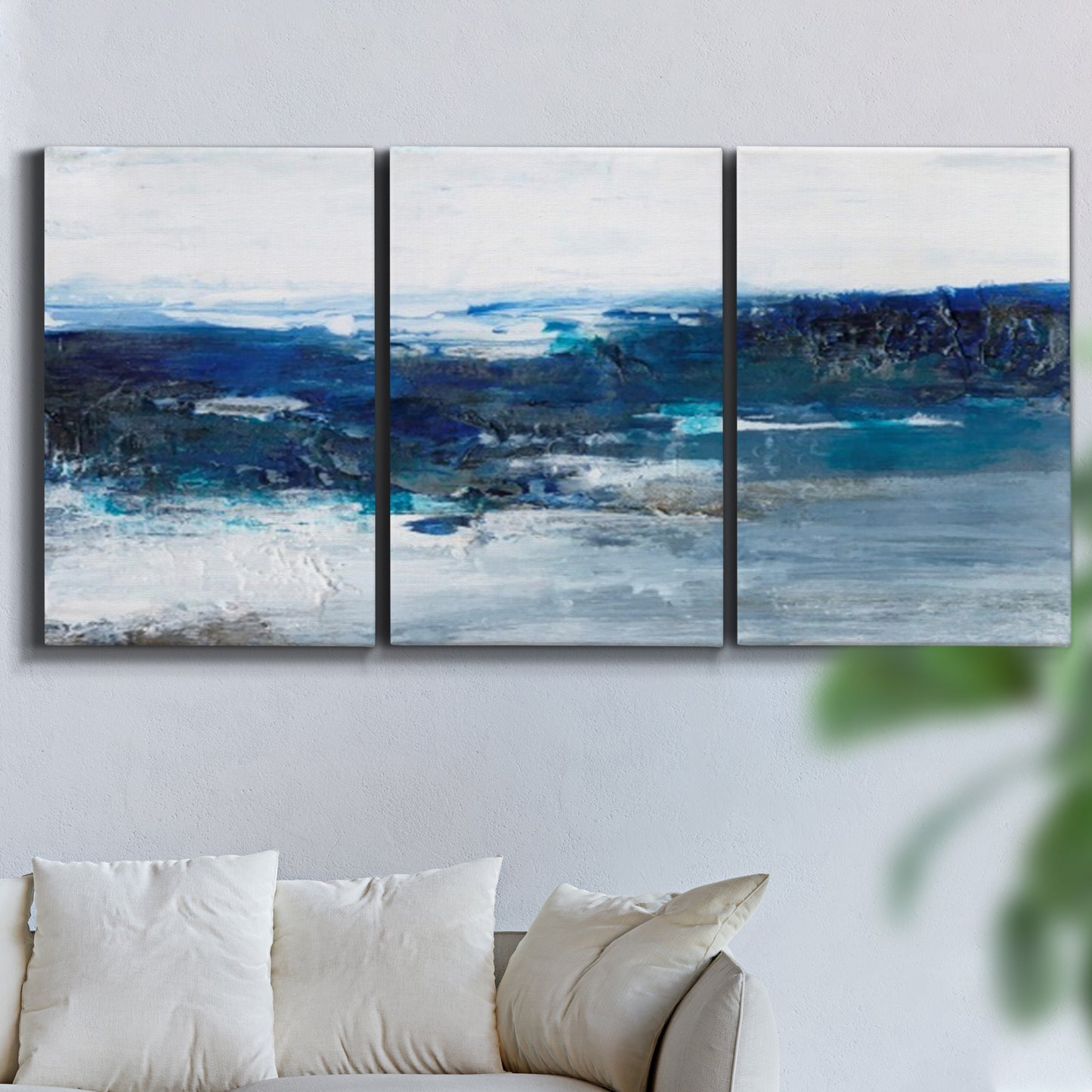 Three-panel canvas wall art featuring moody abstract sea with depth, displayed in a living room above a sofa.