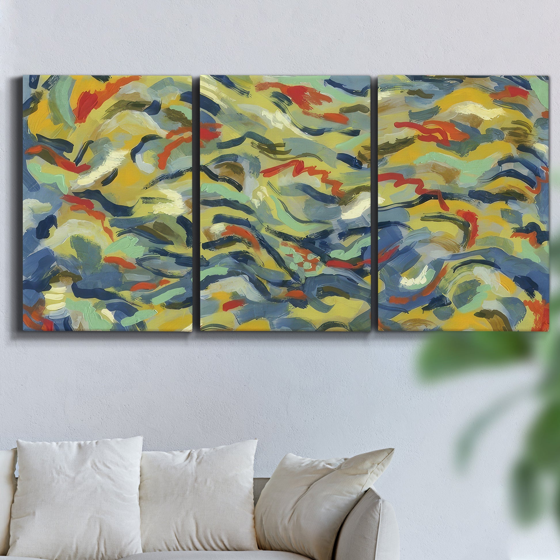 Three-panel canvas wall art featuring colorful abstract river like motion, displayed in a living room above a sofa.